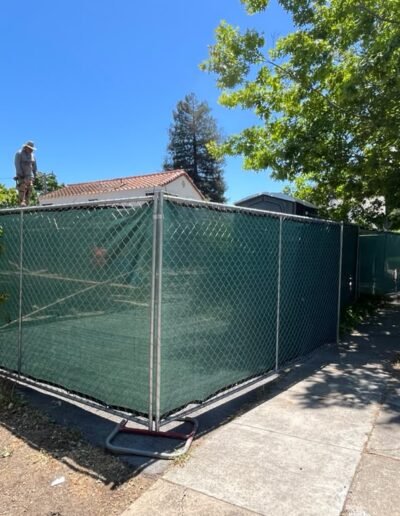 Green temporary construction fence with privacy screen